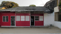 Facade of a small bright-red wooden house.