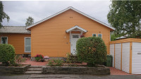 Gable of a small orange-yellow wooden house.