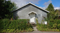 Gable of a small gray wooden house.