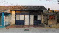 Facade of a small dark-blue wooden house.